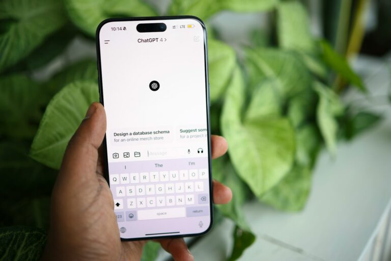 Smartphone affiché de face sur fond végétal, tenu par une main.