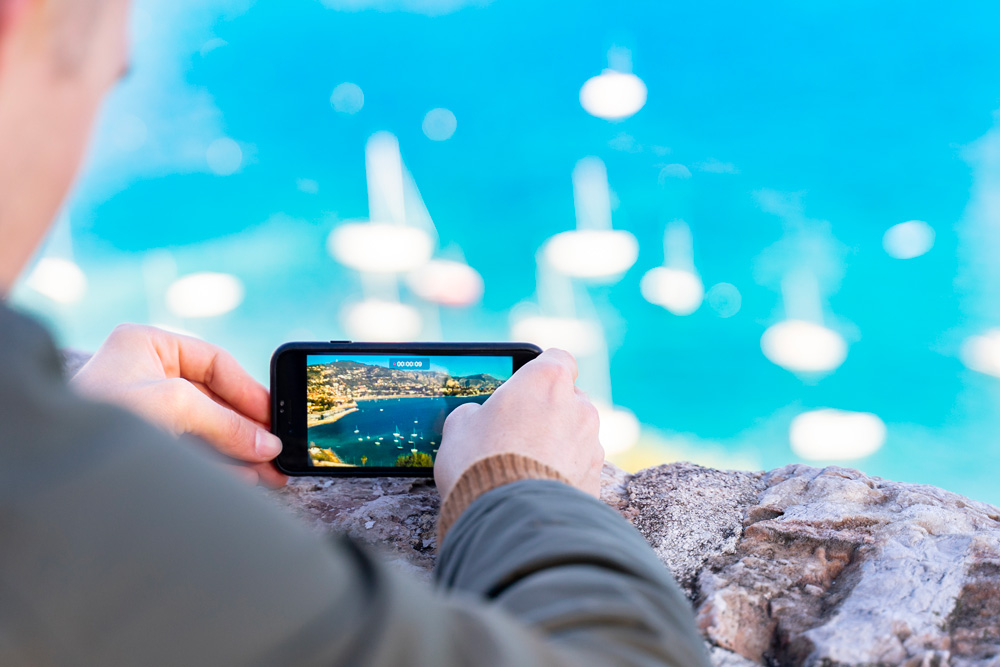 Marketing vidéo local à Nice sur smartphone avec icônes numériques et stratégie digitale en arrière-plan